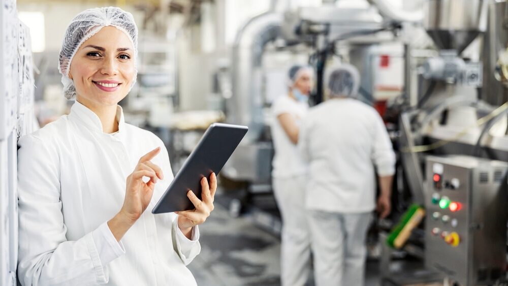 Female,Food,Factory,Inspector,Using,Tablet,And,Smiling